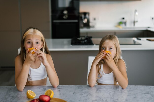 Kinderen eten fruit aan de keukentafel voor het ontbijt.