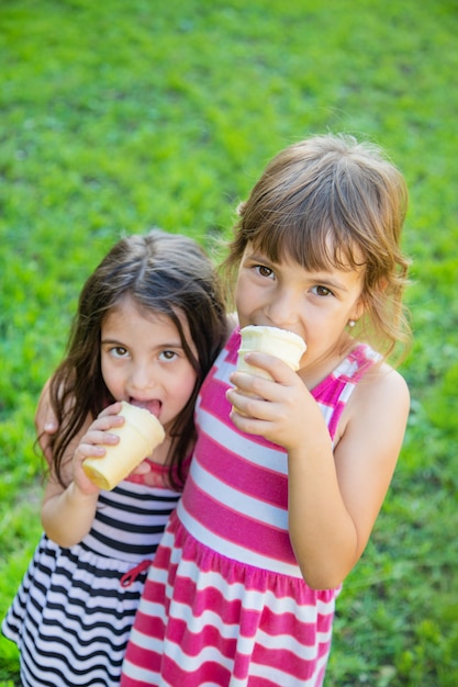 Kinderen eten ijs in het park.