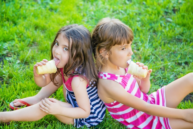 Kinderen eten ijs in het park.