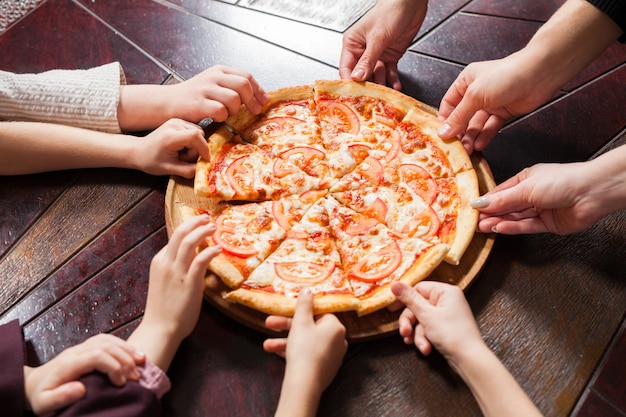 Kinderen eten pizza in een restaurant.