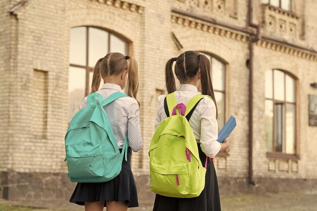 Kinderen gaan naar school schoolmeisjes met rugzakken september concept