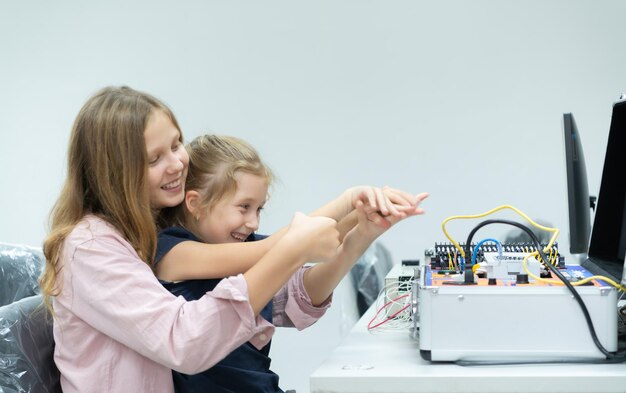 Kinderen gebruiken de handrobottechnologie en hebben plezier met het leren van de elektronische printplaat