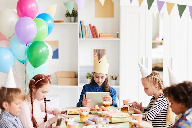 Kinderen gebruiken gadgets op feestje