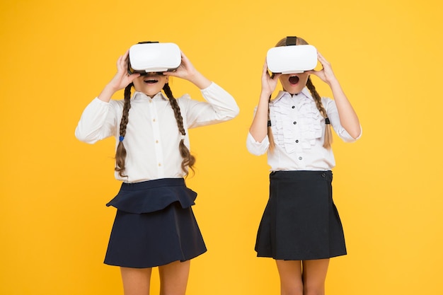 Kinderen gebruiken moderne VR-technologie. Virtuele realiteit. VR-headset. Toekomstig onderwijs. Schoolmeisjes van kinderen dragen een draadloze VR-bril. Augmented reality verkennen. Ervaringen communiceren en beheren projecten.