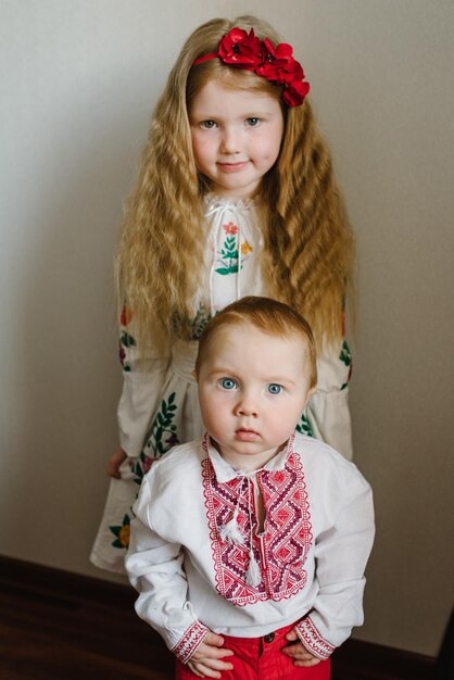 Kinderen gekleed in Oekraïense folkloristische geborduurde kleding Nationale etnische traditionele klederdracht of jurk Een kindmeisje met een krans van klaprozen op zijn hoofd Oekraïense douanetradities