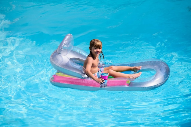 Kinderen gelukkig zomer zomer vakantie kind in zwembad jongen zwemmen bij zwembad grappige jongen op opblaasbare...