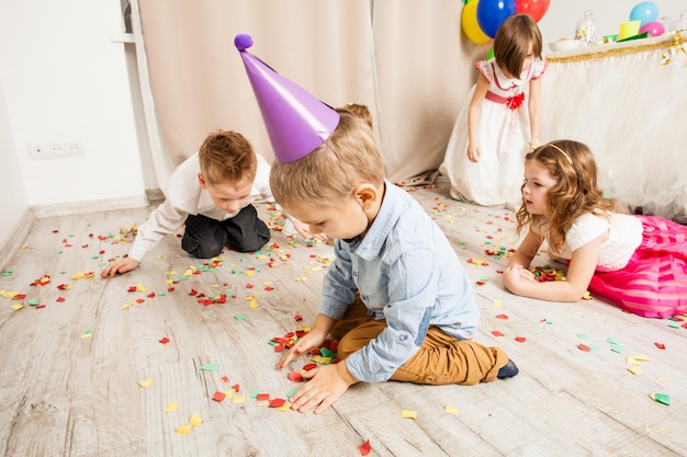 Kinderen gooien kleurrijke confetti op het verjaardagsfeestje