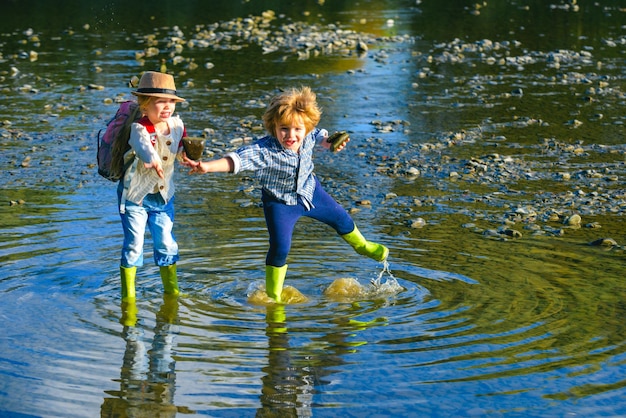 Kinderen gooien stenen naar het water mooie kinderen gooien een steen naar de rivier stenen overslaan