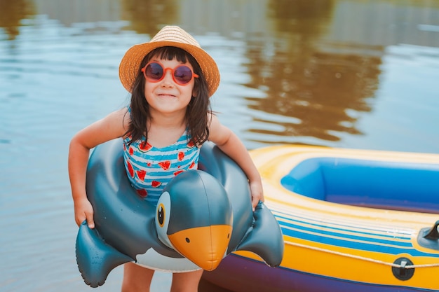 Kinderen hebben plezier en spelen in het water in een vijver buiten de stad in het dorp tijdens de zomervakantie