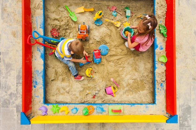 Kinderen hebben plezier in de grote moderne zandbak buiten.