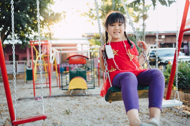 Kinderen hebben plezier met schommel spelen in de speeltuin in het park