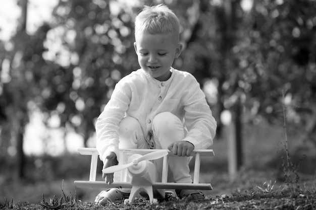 Kinderen hebben plezier met speelgoedvliegtuig in veld tegen natuur achtergrond avontuur en vakanties kinderen