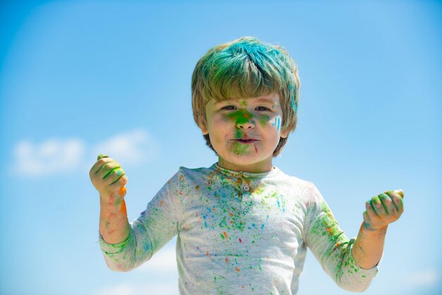 Kinderen holi festival van kleuren geschilderd gezicht van lachende jongen kleine jongen speelt met kleuren