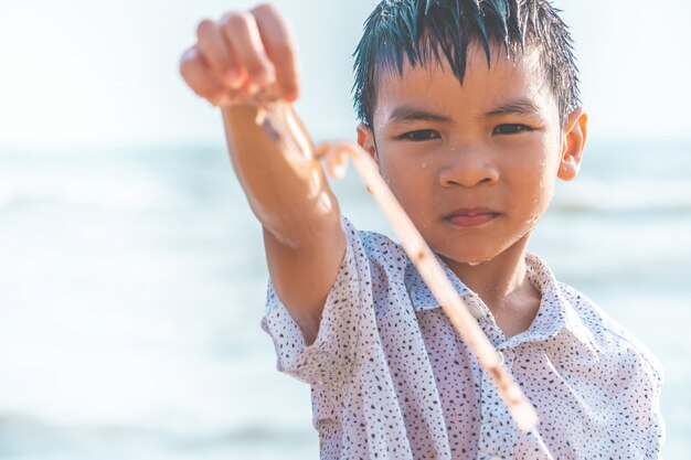 Kinderen houden plastic stro dat hij op het strand vond