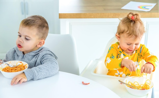 Kinderen in de keuken aan tafel draaien pasta selectieve focus