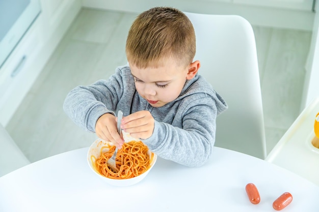 Kinderen in de keuken aan tafel draaien pasta selectieve focus