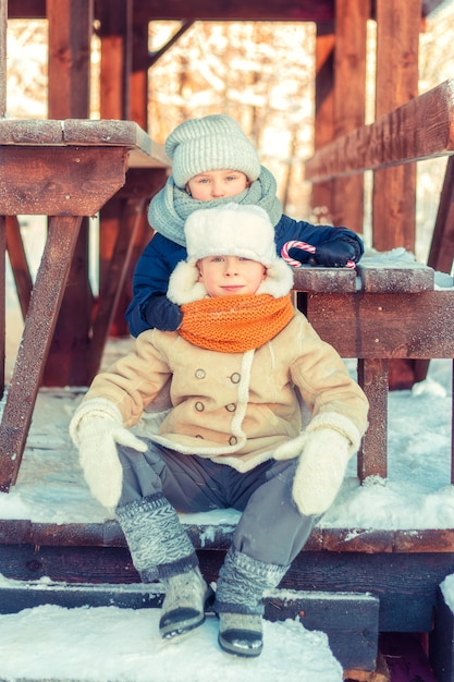 Kinderen in een houten gazebo in een besneeuwd winterwoud