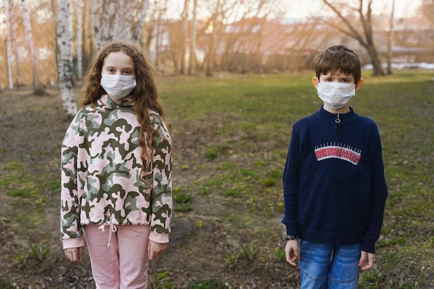 Foto kinderen in een medisch masker buitenshuis.