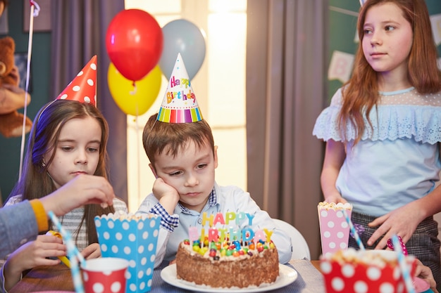 Kinderen in feestmutsen vieren een verjaardag