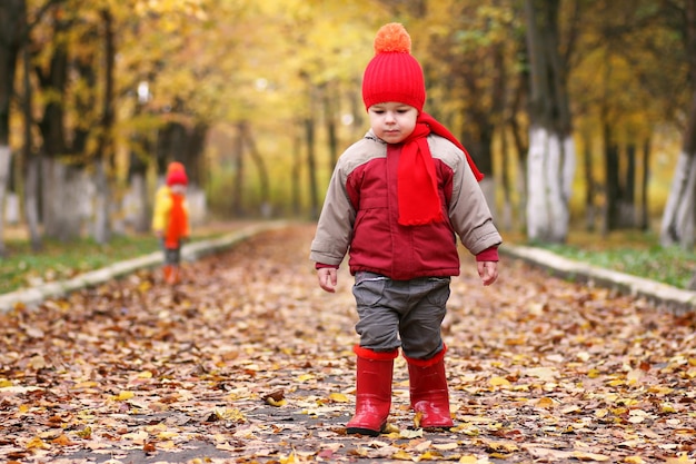 kinderen in herfstpark met pompoen rond herfstbladeren