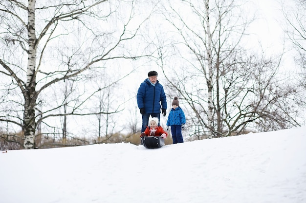 Kinderen in het park in de winter. Kinderen spelen met sneeuw op de speelplaats. Ze boetseren sneeuwmannen en glijden van de heuvels.