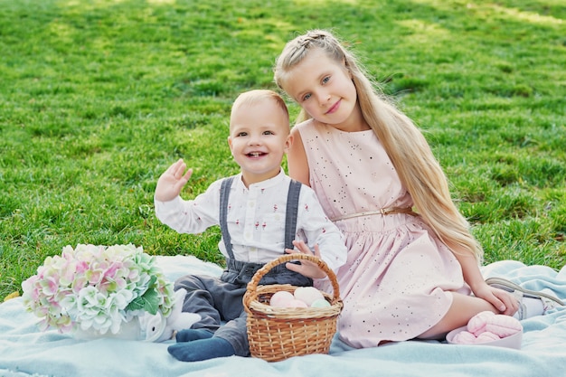 kinderen in het park op Pasen-picknick met eieren en konijn