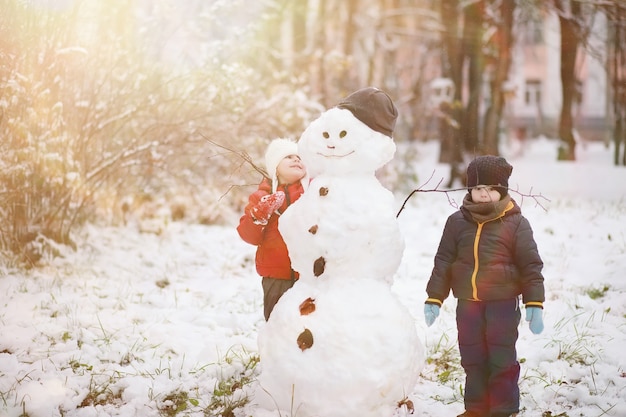 Kinderen in het winterpark spelen met sneeuw