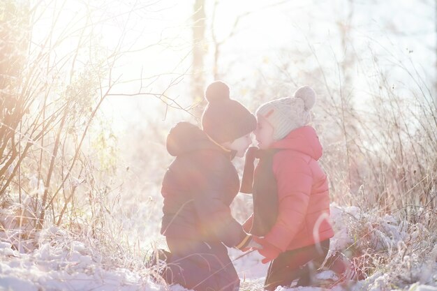 Kinderen in het winterpark spelen met sneeuw