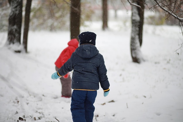 Kinderen in het winterpark spelen met sneeuw