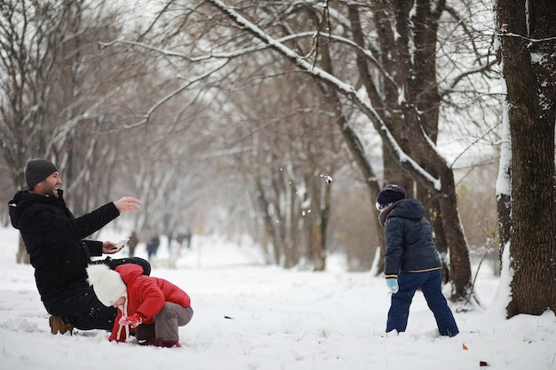 Kinderen in het winterpark spelen met sneeuw