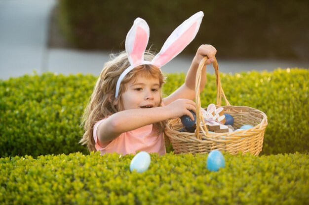 Kinderen in konijnenoren op paaseieren zoeken in de tuin kind eieren verzamelen paaseieren zoeken concept