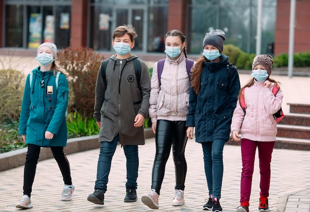 Kinderen in medische maskers verlaten de school.