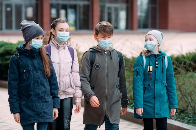 Kinderen in medische maskers verlaten de school.