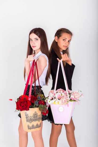 Kinderen in schooluniform met bloemen. Jeugd, bloemenconcept