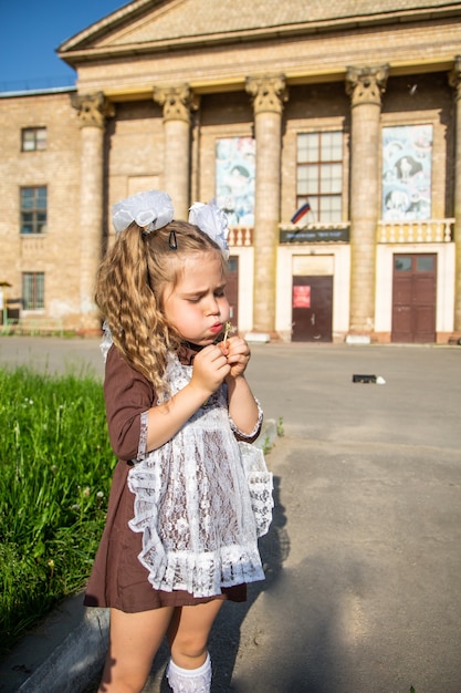 Kinderen in schooluniformen met een aktetas lopen en eten in de buurt van de school