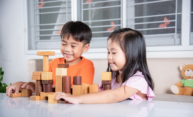 Kinderen jongen en meisje spelen met constructor houten blok bouwen