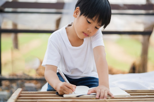 Kinderen jongen schrijven op papier voor huiswerk op school