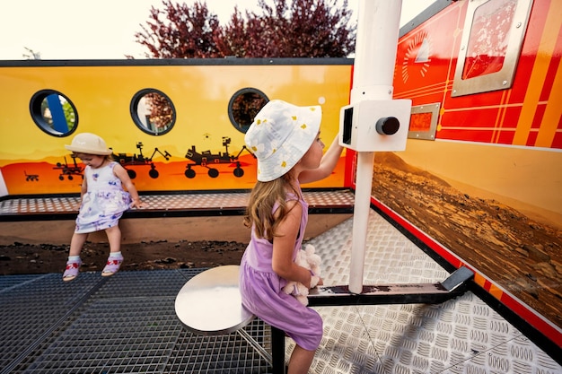 Kinderen kijken door de periscoop in moon rover openluchttentoonstelling in observatorium