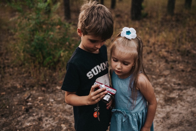 Kinderen kijken naar de foto op de camera in het bos