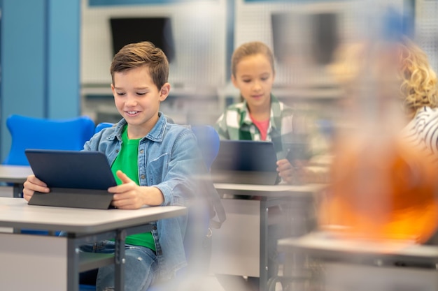 Foto kinderen kijken naar tablets in de klas