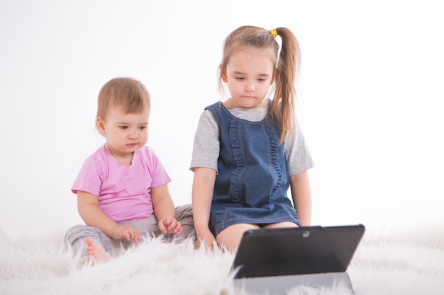 Kinderen kijken naar tekenfilms op de tablet. thuisonderwijs voor meisjes tijdens quarantaine