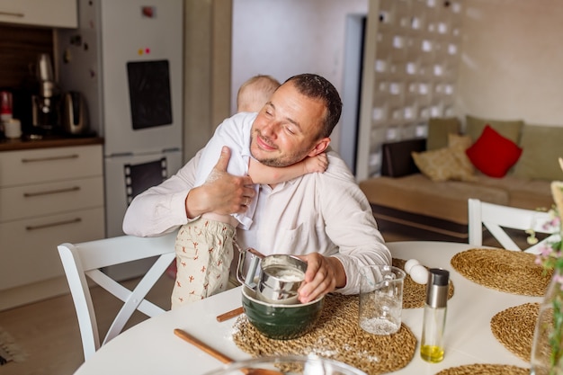 kinderen knuffelen haar vader in de keuken