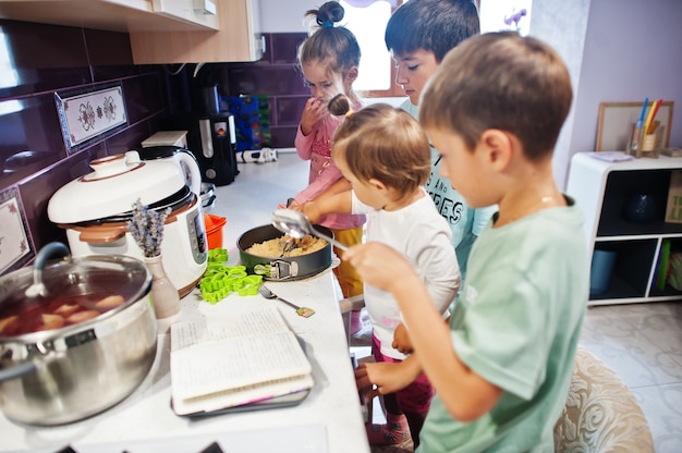 Kinderen koken in de keuken, gelukkige kindermomenten. Ze bereiden cheesecake.