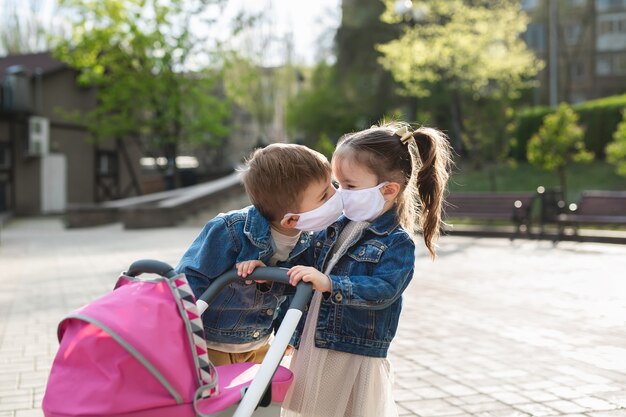 Kinderen kussen in beschermende gezichtsmaskers. Coronavirus (COVID-19