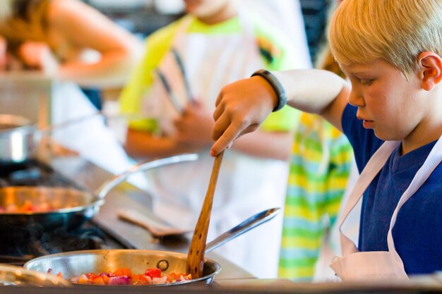 Kinderen leren koken in een kookles.