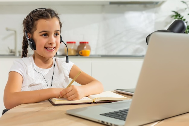 Kinderen leren op afstand. Schattig klein meisje dat laptop thuis met behulp van. Onderwijs, online studie, thuis studeren, technologie, wetenschap, toekomst, afstandsonderwijs, huiswerk, schoolmeisje kinderen levensstijl concept.