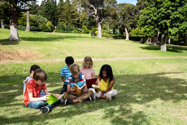 Kinderen lezen boek in het park