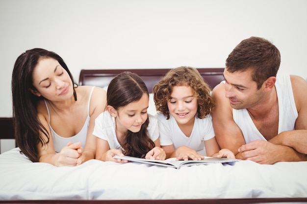 Kinderen lezen boek met ouders thuis