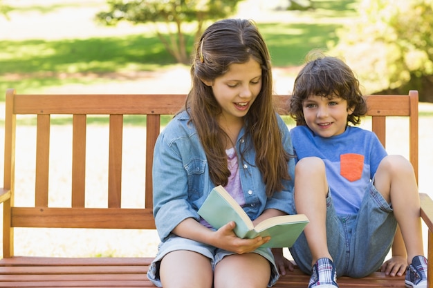 Kinderen lezen boek op bankje