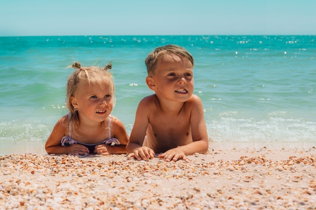 Kinderen liggen op het strand van de zee